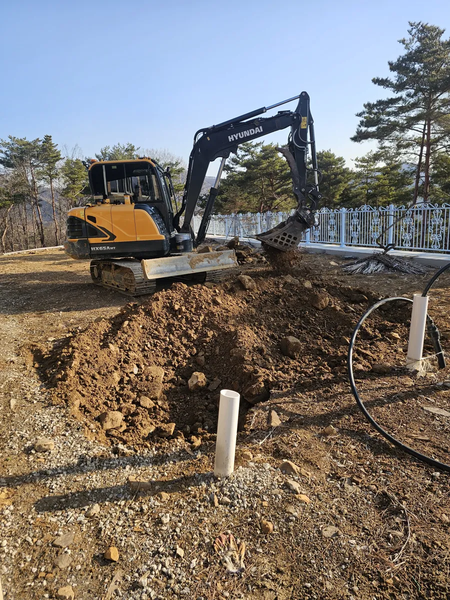 굴삭기로 터파기한 연못 현장에 PVC 배관을 먼저 매설해 둔 여과 배관 준비 모습